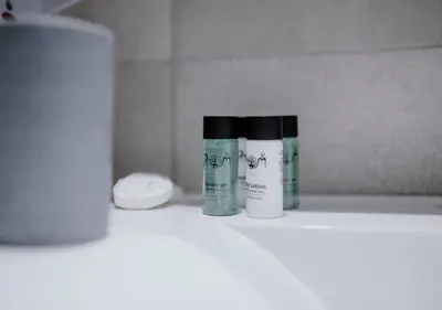 two bottles of medicines sitting on a shelf in a bathroom at ROH Suites in Athens