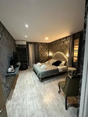 a bedroom with a bed and a chair at ROH Suites in Athens
