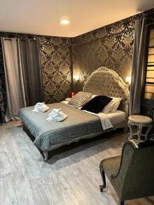 a bedroom with a bed and a chair at ROH Suites in Athens