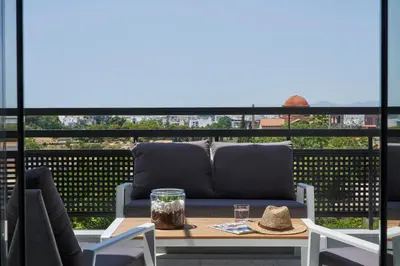 a patio with a couch and a table on a balcony at NLH KERAMEIKOS - Neighborhood Lifestyle Hotels in Athens