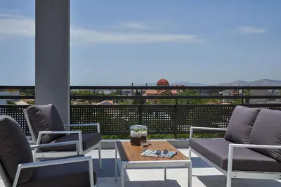 a patio with two chairs and a coffee table on a balcony at NLH KERAMEIKOS - Neighborhood Lifestyle Hotels in Athens