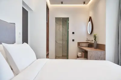 a bedroom with a large white bed and a bathroom at NLH KERAMEIKOS - Neighborhood Lifestyle Hotels in Athens