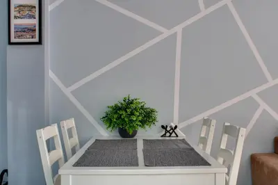 a table with two chairs and a potted plant on it at Modern Cozy Apartment in Downtown Athens in Athens
