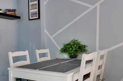 a white table with two chairs and a potted plant at Modern Cozy Apartment in Downtown Athens in Athens