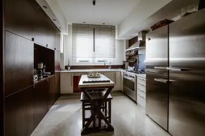 a kitchen with wooden cabinets and a table in it at The Magnolia - Sophisticated residence in Athens