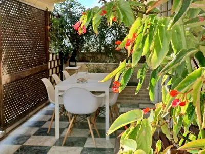 a white table and chairs on a patio with flowers at The Magnolia - Sophisticated residence in Athens