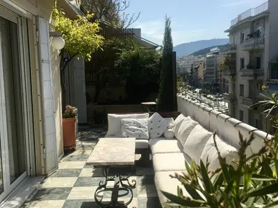 a balcony with a couch and a table on a building at The Magnolia - Sophisticated residence in Athens