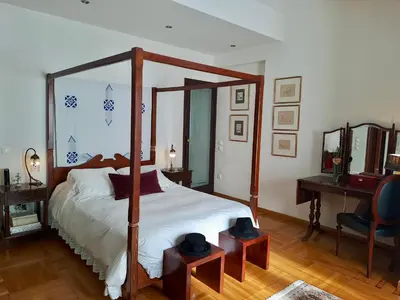 a bedroom with a canopy bed and a desk at The Magnolia - Sophisticated residence in Athens