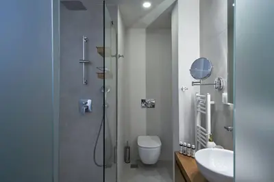 a bathroom with a shower and a toilet and a sink at Ilisia Park Contemporary 2BD Condo in Athens