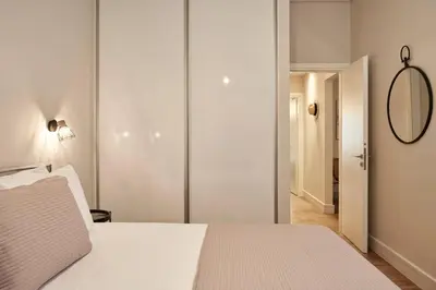 a bedroom with a white bed and a mirror at Ilisia Park Contemporary 2BD Condo in Athens