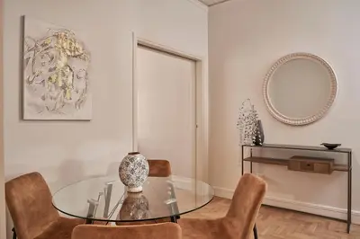 a dining room with a glass table and chairs at Ilisia Park Contemporary 2BD Condo in Athens