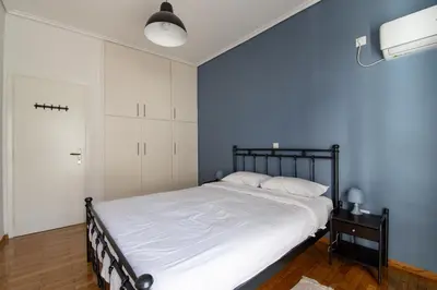 a bedroom with a bed and a blue wall at Marina Zeas Livemodern in Piraeus