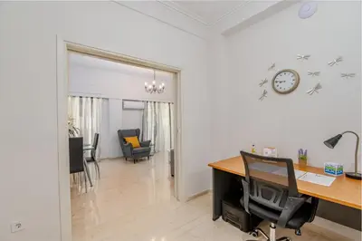 an office with a desk and a clock on the wall at Marina Zeas Livemodern in Piraeus