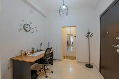 an office with a desk and a clock on the wall at Marina Zeas Livemodern in Piraeus