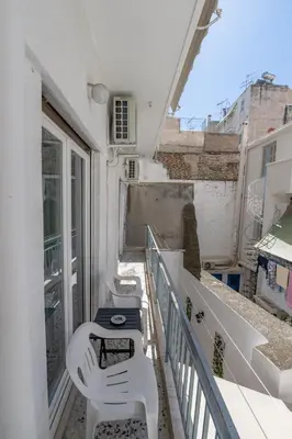a balcony with a row of white chairs on it at Marina Zeas Livemodern in Piraeus