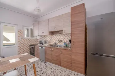 a kitchen with wooden cabinets and a stainless steel refrigerator at Marina Zeas Livemodern in Piraeus