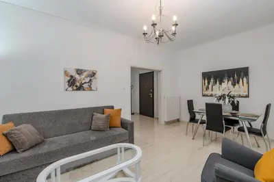 a living room with a couch and a dining room at Marina Zeas Livemodern in Piraeus