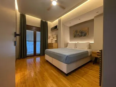 a bedroom with a large bed and a wooden floor at Acropolis Lux Apartment in Athens