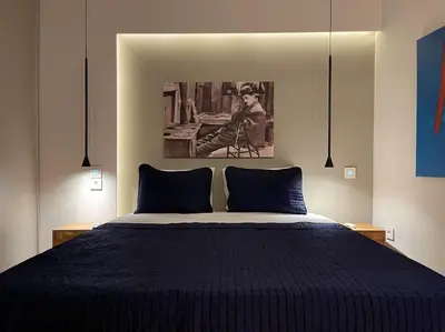 a bedroom with a blue bed with a painting on the wall at Acropolis Lux Apartment in Athens