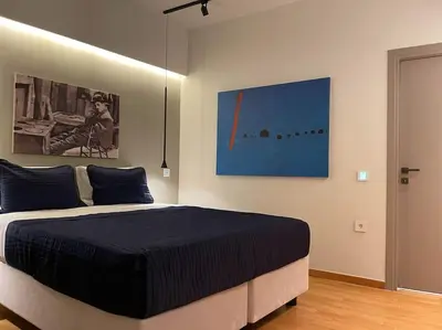 a bedroom with a bed and a painting on the wall at Acropolis Lux Apartment in Athens