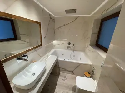 a bathroom with a white tub and a sink and a tub at Acropolis Lux Apartment in Athens