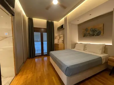a bedroom with a large bed and a bathroom at Acropolis Lux Apartment in Athens