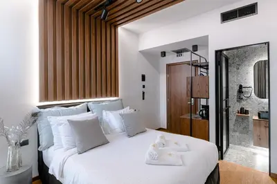 a bedroom with a white bed with towels on it at Mamy Blue Slow Living in Athens