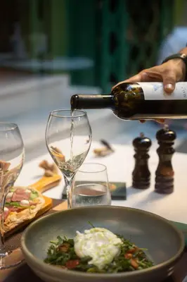 a person pouring wine into a wine glass at Mamy Blue Slow Living in Athens