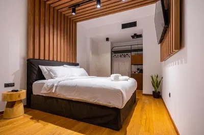 a bedroom with a large bed with a black headboard at Mamy Blue Slow Living in Athens
