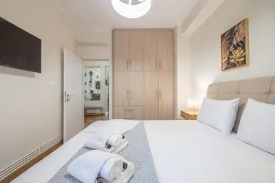 a bedroom with a large white bed with towels on it at Boutique Suite by CloudKeys in Athens