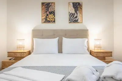 a bedroom with a large white bed with two lamps at Boutique Suite by CloudKeys in Athens