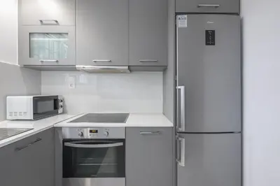 a white kitchen with a refrigerator and a microwave at Boutique Suite by CloudKeys in Athens