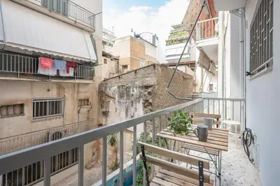 a balcony with a wooden bench and some buildings at Boutique Suite by CloudKeys in Athens