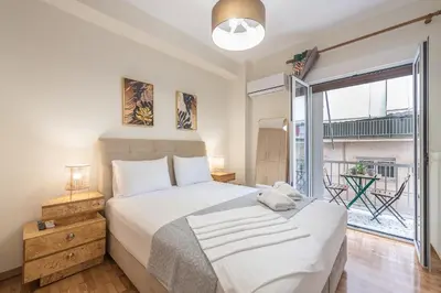 a bedroom with a bed and a large window at Boutique Suite by CloudKeys in Athens