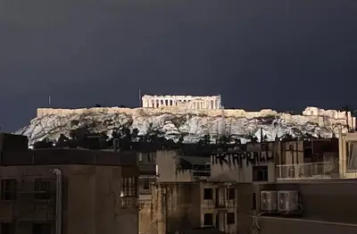 a building on top of a mountain with buildings at Here Comes The Sun in Athens