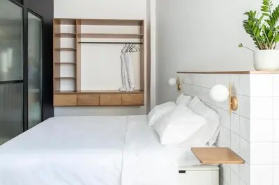 a bedroom with a white bed with white pillows at Here Comes The Sun in Athens
