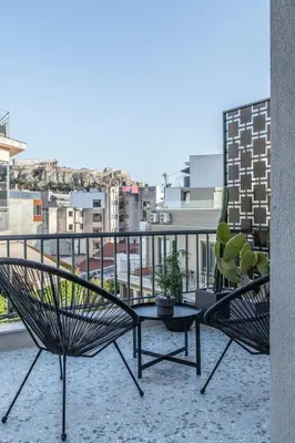 two chairs and a table on a balcony with a view at Here Comes The Sun in Athens