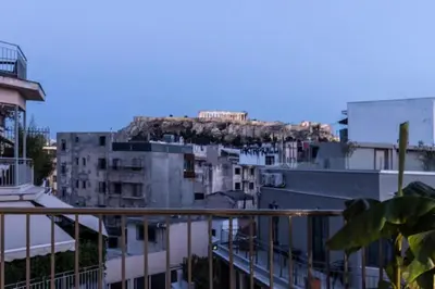a view of a city from a balcony with buildings at Here Comes The Sun in Athens