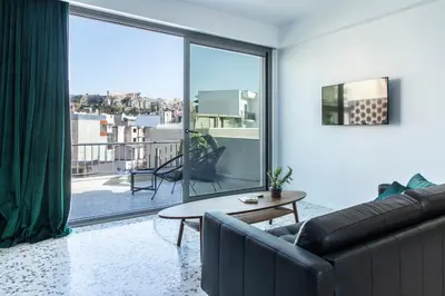 a living room with a couch and a large window at Here Comes The Sun in Athens