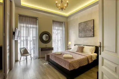 a bedroom with a bed and a chair and a chandelier at Plaka Filotheis House B in Athens