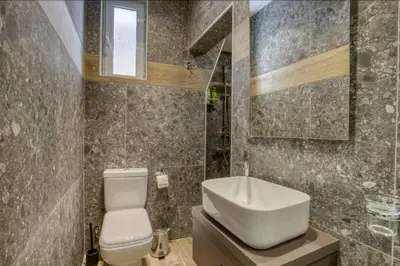 a bathroom with a white toilet and a sink at Plaka Filotheis House A in Athens