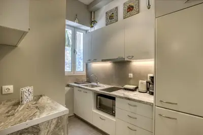 a kitchen with white cabinets and a sink at Plaka Filotheis House A in Athens
