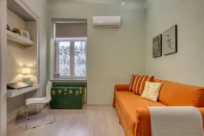 a living room with an orange couch and a window at Plaka Filotheis House A in Athens