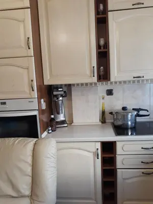 a kitchen with white cabinets and a white couch at Mandy's cosy luxury flat in Piraeus