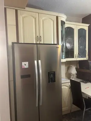 a stainless steel refrigerator in a kitchen with cabinets at Mandy's cosy luxury flat in Piraeus