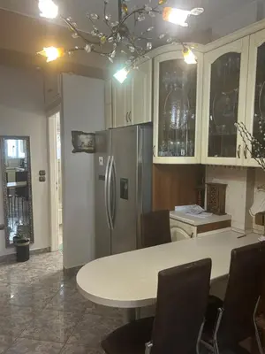 a kitchen with a table and a refrigerator at Mandy's cosy luxury flat in Piraeus