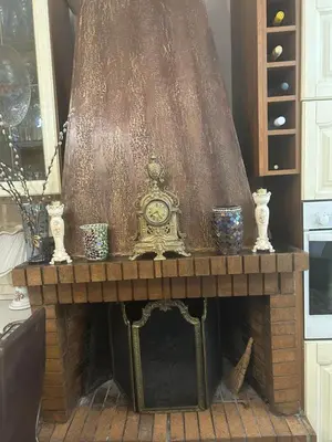 a fireplace with a clock on top of it at Mandy's cosy luxury flat in Piraeus