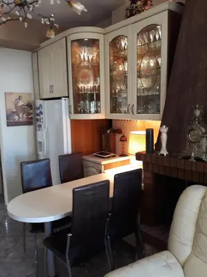 a kitchen with a table and chairs and a refrigerator at Mandy's cosy luxury flat in Piraeus