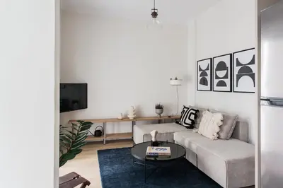 a living room with a couch and a table at Pristine 1BR Apartment in Ampelokipoi Area by UPSTREET in Athens
