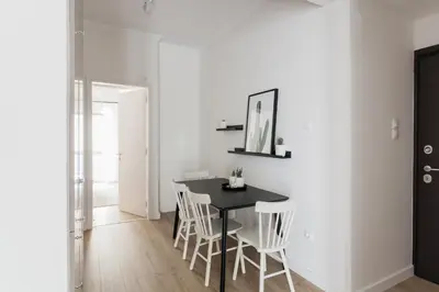 a dining room with a black table and white chairs at Pristine 1BR Apartment in Ampelokipoi Area by UPSTREET in Athens